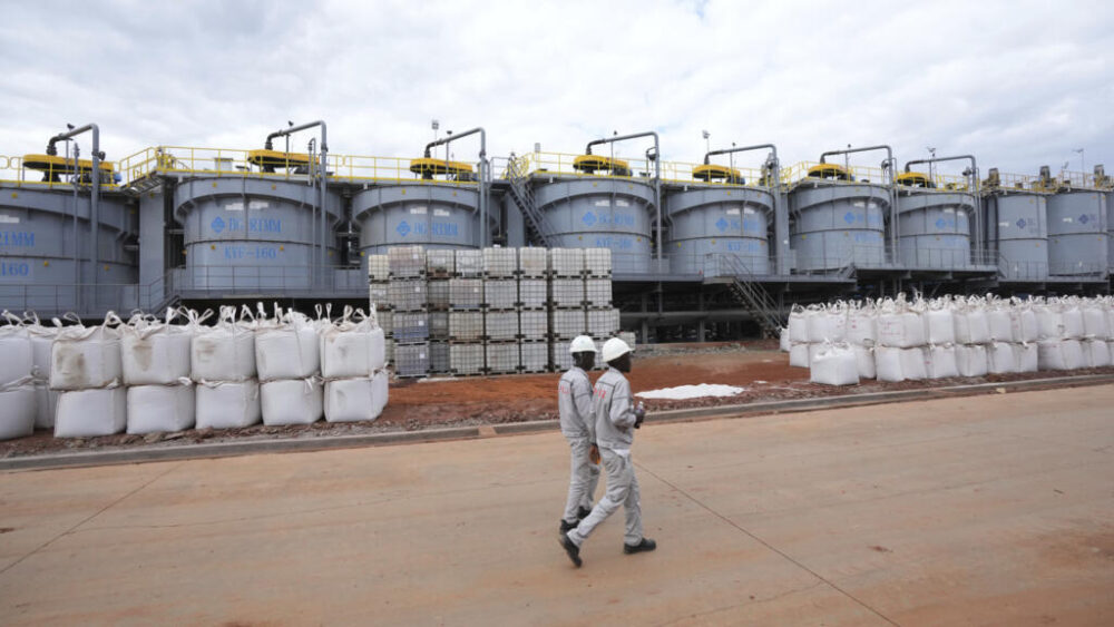Trabajadores pasan junto a sacos llenos de litio, en la planta de procesamiento de Prospect Lithium Zimbabwe en Goromonzi, a unos 80 kilómetros al sureste de la capital, Harare, el 5 de julio de 2023.