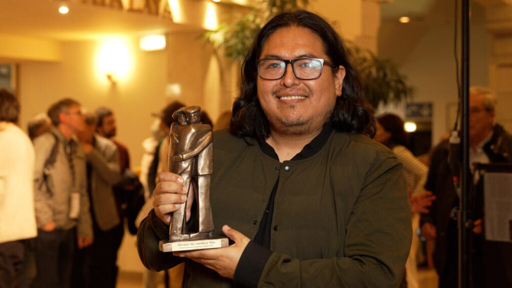 El director de cine boliviano Álvaro Olmos Torrico posa con el premio El Abrazo.
