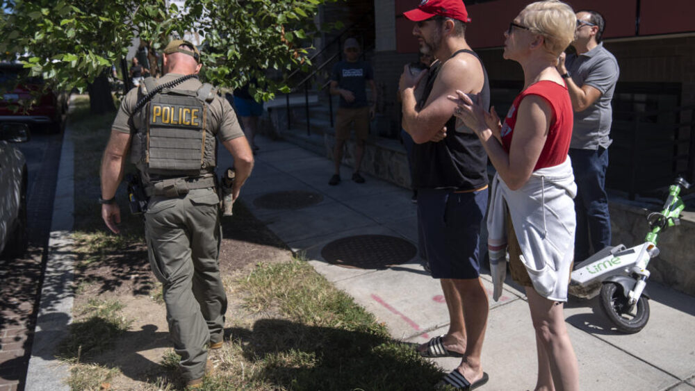 La gente reprende a un agente del Servicio de Inmigración y Control de Aduanas (ICE) mientras se marcha tras el fin de un control realizado por el Departamento de Policía Metropolitana y agencias federales en Georgia Avenue, en la zona norte de Washington, el sábado 30 de agosto de 2025. (AP Photo/Mark Schiefelbein)