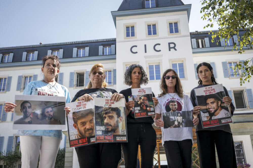 (De izq. a drcha.) Merav Gilboa-Dalal, Silvia Cunio, Wiki Cohen y Galia David muestran retratos de sus hijos, junto a Yeela, con una imagen de su hermano, el 12 de agosto de 2025 en la sede del Comité Internacional de la Cruz Roja, en Ginebra