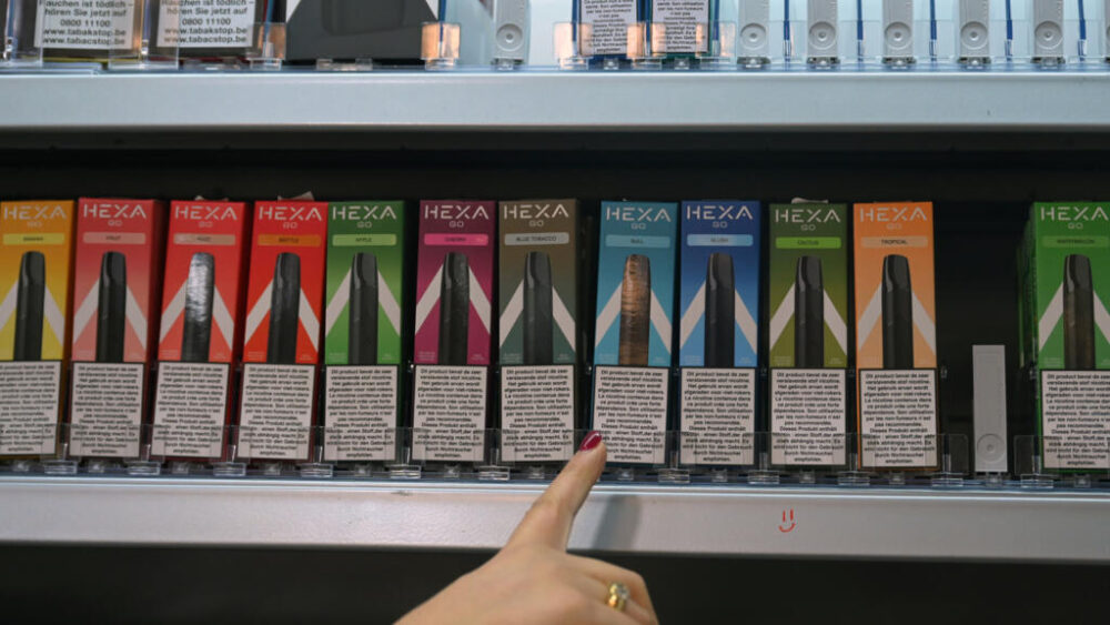 Una dependienta muestra los cigarrillos electrónicos a la venta en su tienda de Bruselas, el 12 de diciembre de 2024 en la capital belga