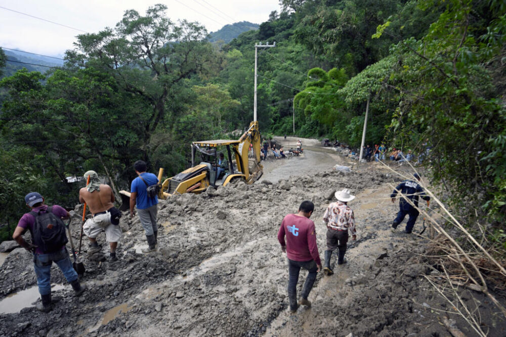Los vecinos limpian y retiran el barro de un deslizamiento de tierra en la entrada del pueblo de San Bartolo Tutotepec, en el estado de Hidalgo, México, el 13 de octubre de 2025.