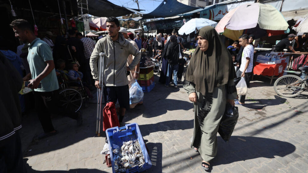Unos palestinos compran en un mercado en el campamento de refugiados de Nuseirat, en el centro de la Franja de Gaza, el 15 de octubre de 2025