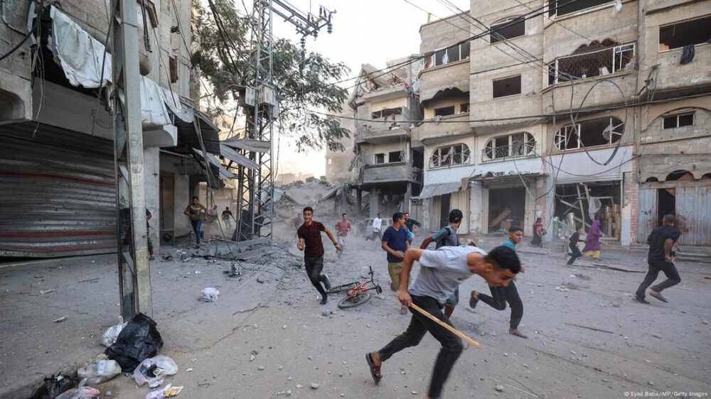 Un grupo de personas corre a refugiarse tras un ataque israelí de represalia en el campamento de refugiados palestinos de Bureij, en Gaza (19.10.2025).