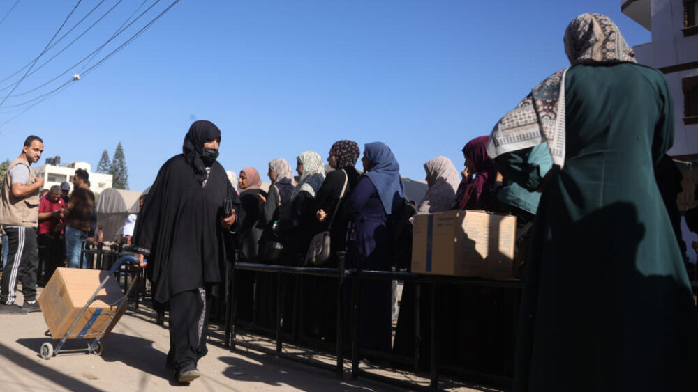Una palestina transporta una caja de comida proporcionada por el Programa Mundial de Alimentos (PMA) el 27 de octubre de 2025 en un centro de distribución en Al Zawayda, en el centro de la Franja de Gaza