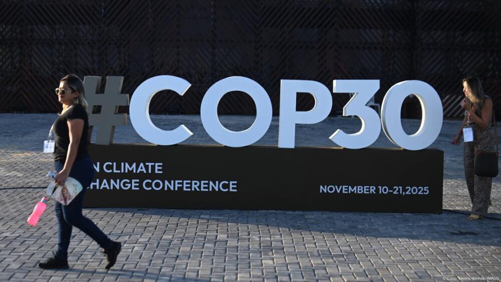 Una mujer pasa frente a un cartel con el logo de la COP30 en Belém. Una mujer pasa frente a un cartel con el logo de la COP30 en Belém.