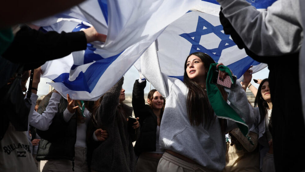 Varias personas bailan bajo una bandera israelí durante un acto organizado por la comunidad judía en Londres el 5 de octubre de 2025 para honrar a los que perdieron la vida en los ataques de Hamás del 7 de octubre de 2023 en Israel