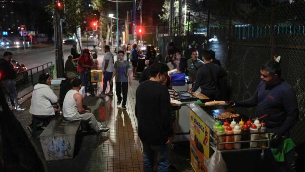 Venezolanos venden comida tradicional en sus carritos callejeros en Santiago, Chile, el 16 de octubre de 2025.