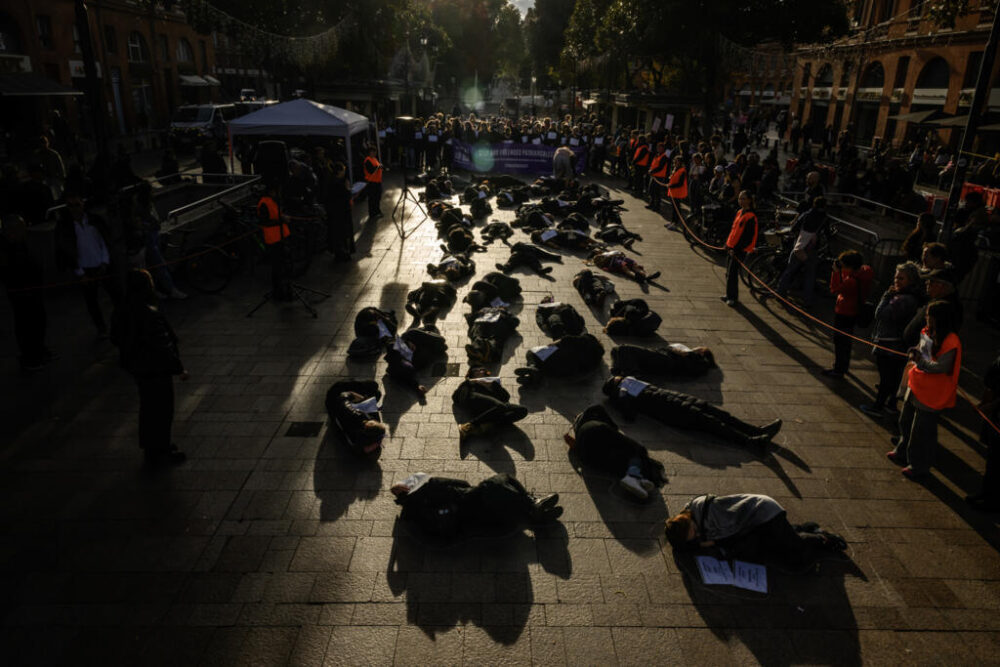 Varias activistas representan a mujeres muertas en una manifestación de homenaje a las víctimas de la violencia machista, el 16 de noviembre de 2025 en la ciudad de Toulouse, al sur de Francia