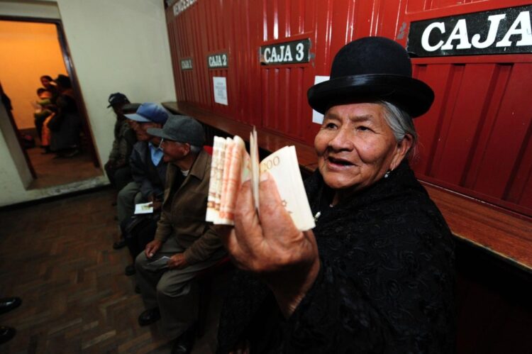 Una adulta mayor muestra el dinero cobrado de su Renta Dignidad.
