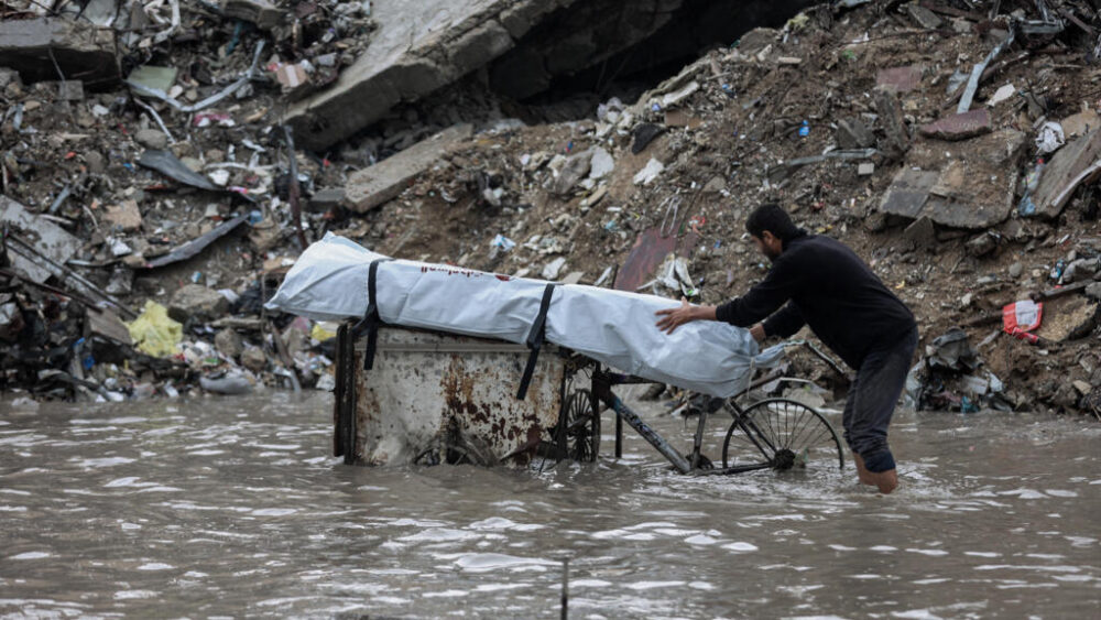 Un hombre empuja un carro en una zona inundada por las fuertes lluvias en un campamento de desplazados palestinos en Ciudad de Gaza el 25 de noviembre de 2025