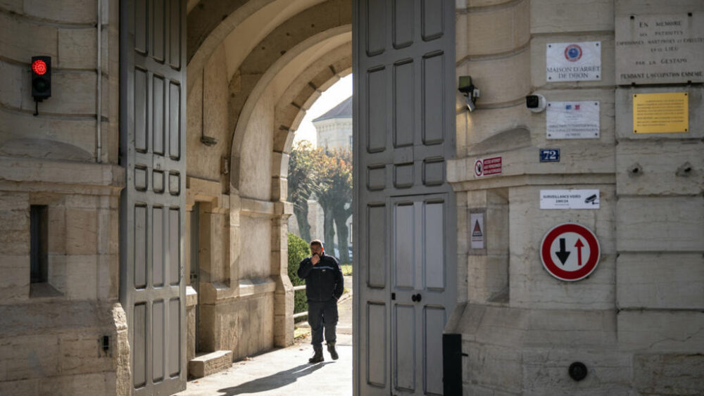 Un funcionario de prisiones permances en la entrada de la cárcel de Dijon, en Francia, el 27 de noviembre de 2025, tras la fuga de dos presos