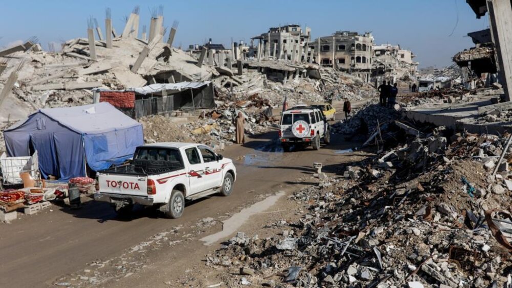 Unos militantes Hamás acompañan a unos trabajadores del Comité Internacional de la Cruz Roja para iniciar la búsqueda de los restos de dos rehenes israelíes el 1 de diciembre de 2025 en el campamento de refugiados de Jabalia, en la Franja de Gaza