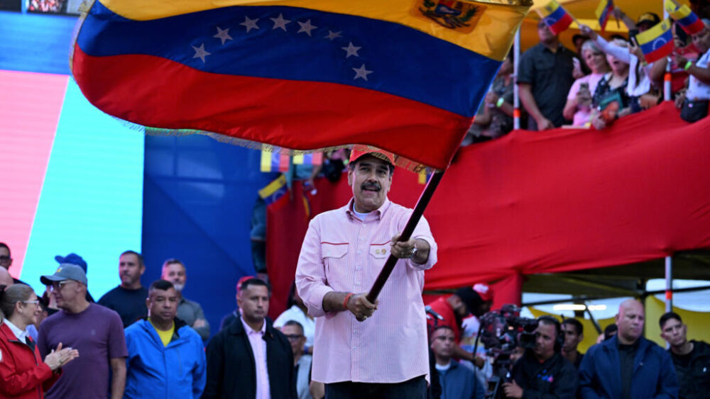 El presidente de Venezuela, Nicolás Maduro, ondea una bandera en Caracas el 1 de diciembre de 2025, durante una concentración contra el despliegue militar de Estados Unidos
