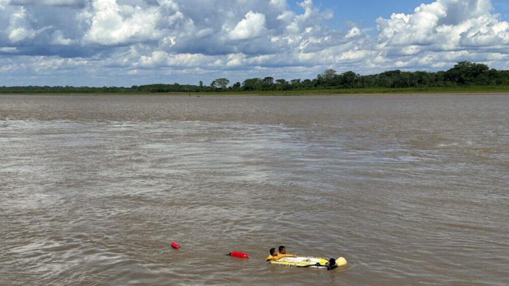 Una imagen divulgada por la Policía Nacional de Perú muestra a un equipo de rescate cerca de los restos de un barco afectado por el deslizamiento de tierra en el puerto fluvial de Iparia, en el departamento de Ucayali, el 1 de diciembre de 2025 en el centro de Perú