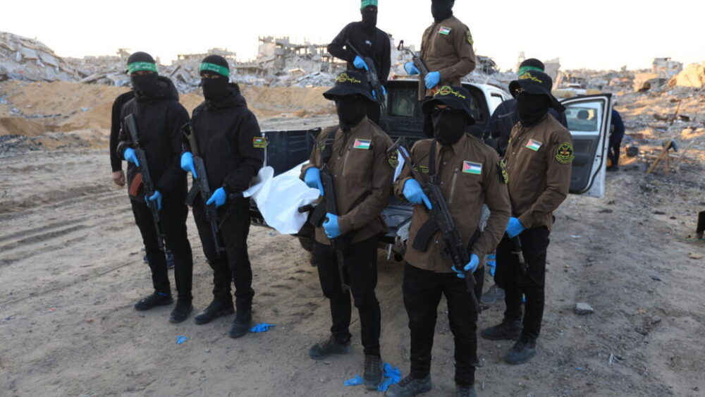 Militantes de los grupos Hamás y Yihad Islámica trasladan en una bolsa blanca los restos mortales de un supuesto rehén israelí, el 3 de diciembre de 2025 en la ciudad de Beit Lahia, al norte de la Franja de Gaza