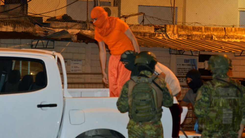 Las fuerzas armadas escoltan hasta un camión a dos presos de la cárcel de Machala, en Ecuador, el 7 de diciembre de 2025, tras el hallazgo de varios cuerpos