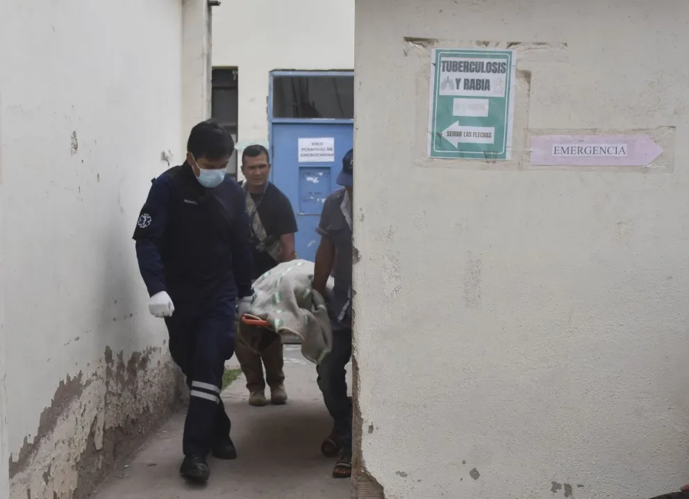 Autoridades policiales transportan a uno de los fallecidos. FOTO: APG