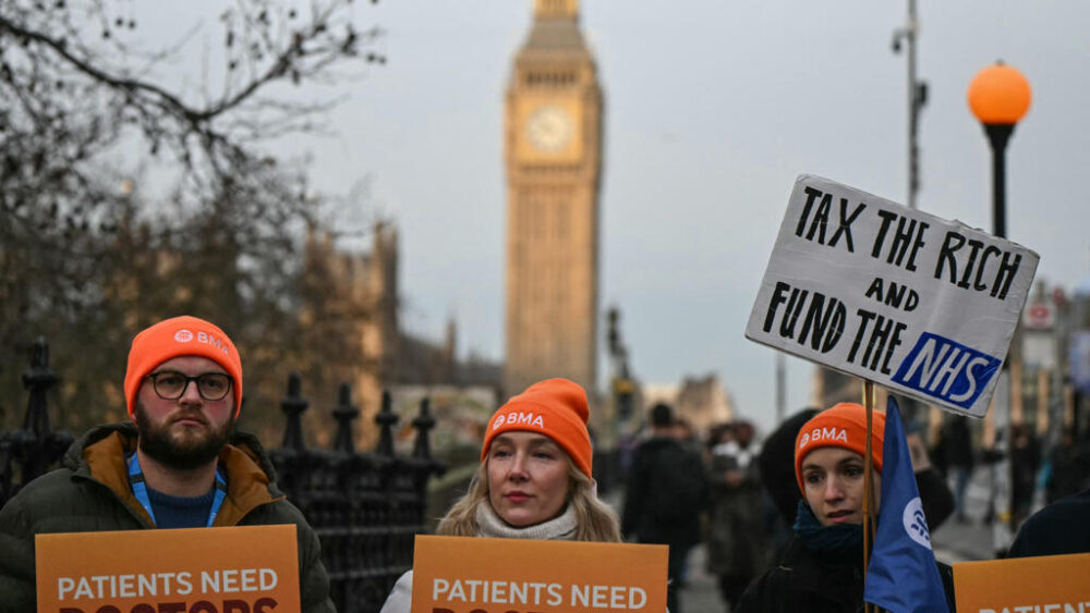 Los miembros del personal sostienen pancartas mientras permanecen en un piquete durante el primer día de una huelga de cinco días de los médicos residentes frente al Hospital St Thomas, en el centro de Londres, el 17 de diciembre de 2025. Los médicos de Inglaterra votaron el 15 de diciembre a favor de llevar a cabo una huelga de cinco días a partir de esta semana, en plena temporada navideña, mientras una epidemia de "supergripe" se extiende por todo el país.