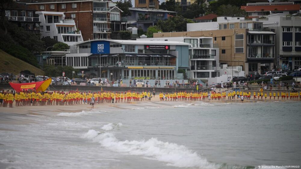 Una fila de gente con uniforme amarillo se alinea a la orilla del mar en la playa que fue escenario del atentado hace una semana para honrar a las víctimas. Una fila de gente con uniforme amarillo se alinea a la orilla del mar en la playa que fue escenario del atentado hace una semana para honrar a las víctimas.