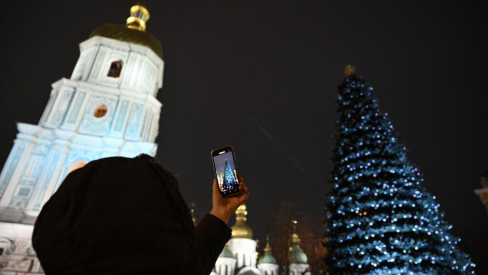 Una persona fotografía el árbol de navidad de la Plaza de Santa Sofía de Kiev el 5 de diciembre de 2025