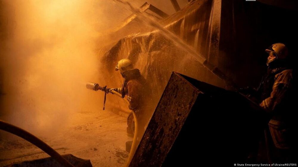 Dos bomberos apuntan a los restos humeantes con sendas mangueras en un edificio derruido. Dos bomberos apuntan a los restos humeantes con sendas mangueras en un edificio derruido.