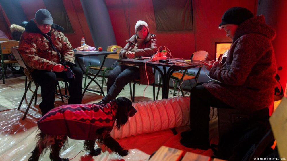 La gente se calienta en una tienda de campaña proporcionada por los servicios de emergencia para los residentes de Kiev, cuyos apartamentos se han quedado sin calefacción mientras los temperaturas están por debajo de los cero grados, tras ataques rusos a la infraestructura energética ucraniana. La gente se calienta en una tienda de campaña proporcionada por los servicios de emergencia para los residentes de Kiev, cuyos apartamentos se han quedado sin calefacción mientras los temperaturas están por debajo de los cero grados, tras ataques rusos a la infraestructura energética ucraniana.