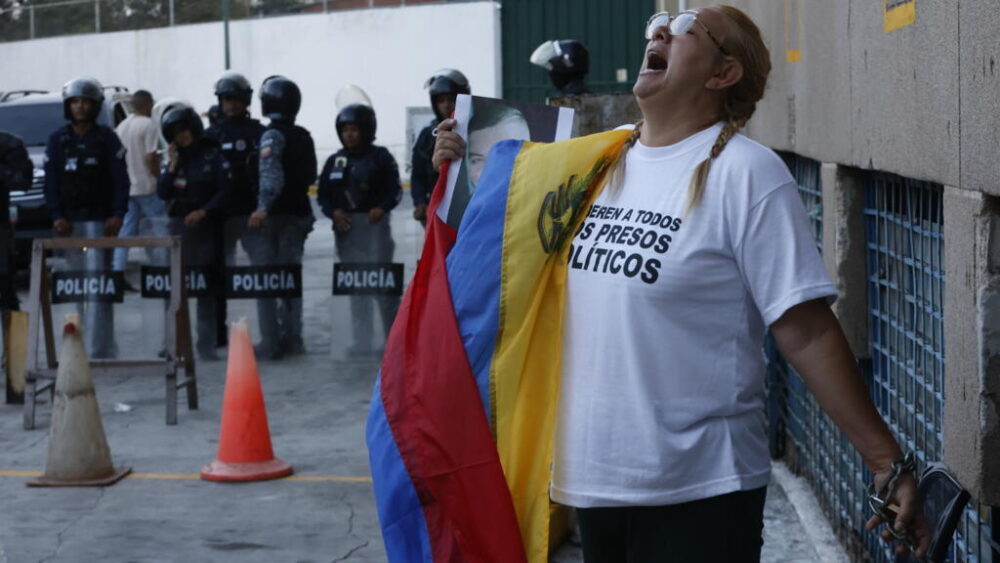 Evelis Cano, madre del prisionero venezolano Jack Tantak Cano, grita encadenada frente al portón de los calabozos de la Policía Nacional en Caracas