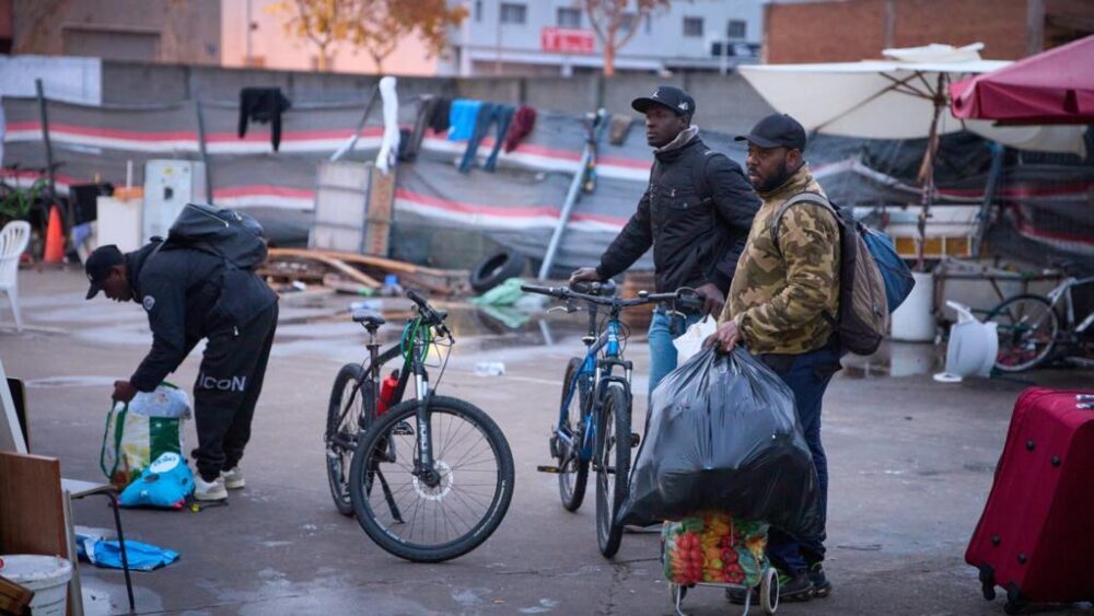 Migrantes recogen sus pertenencias mientras la policía comienza a ejecutar órdenes de desalojo en un edificio escolar abandonado donde vivían cientos de migrantes, en su mayoría indocumentados, en Badalona, cerca de Barcelona, España, el miércoles 17 de diciembre de 2025.