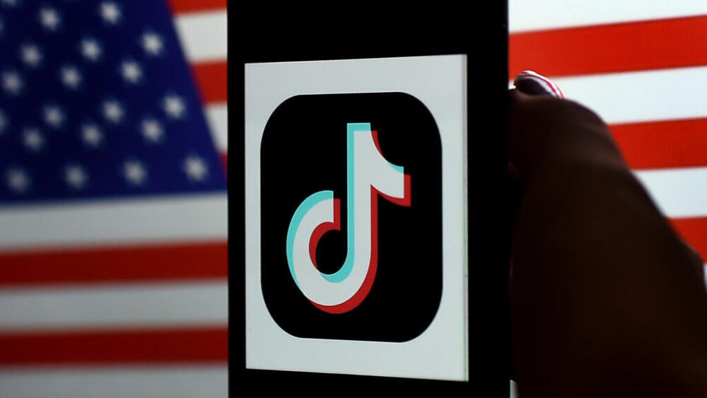 El logotipo de la plataforma de vídeo compartidos TikTok, fotografiado en la pantalla de un teléfono móvil, con la bandera de Estados Unidos de fondo, el 3 de agosto de 2020 en Arlington (Virginia)