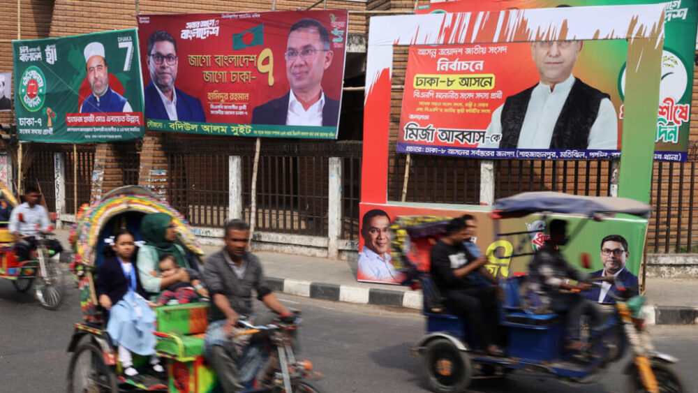 Vehículos pasan junto a pancartas de la campaña electoral previa a las elecciones nacionales, en Daca, Bangladesh, el 10 de febrero de 2026.