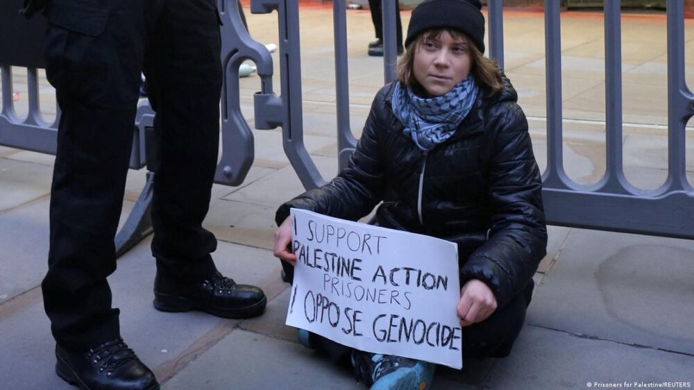 La activista climática sueca Greta Thunberg sentada en el suelo, con una pancarta en la que lee: 'Apoyo a los presos de Palestine Action. Me opongo al genocidio'", durante un acto de apoyo a los ocho manifestantes de Acción Palestina que hacían huelga de hambre en prisión. A su lado, las piernas y botas de un agente del orden. La activista climática sueca Greta Thunberg sentada en el suelo, con una pancarta en la que lee: 'Apoyo a los presos de Palestine Action. Me opongo al genocidio'", durante un acto de apoyo a los ocho manifestantes de Acción Palestina que hacían huelga de hambre en prisión. A su lado, las piernas y botas de un agente del orden.