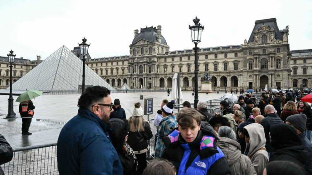 Turistas frente al Museo del Louvre. Imagen de ilustración.