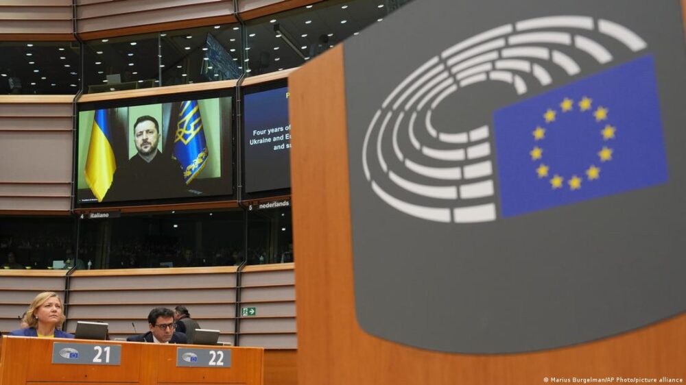 El presidente ucraniano, en una pantalla, durante su intervención ante el hemiciclo europeo. El presidente ucraniano, en una pantalla, durante su intervención ante el hemiciclo europeo.