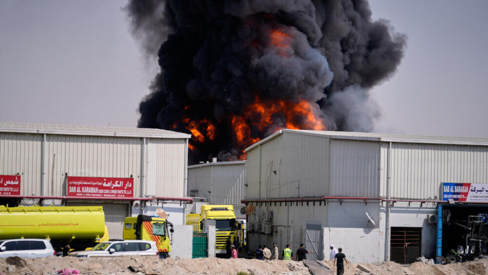 Llamas y humo negro se elevan desde un almacén en la zona industrial de Sharjah City, en los Emiratos Árabes Unidos, el domingo 1 de marzo de 2026, tras las noticias de ataques iraníes en Dubái.