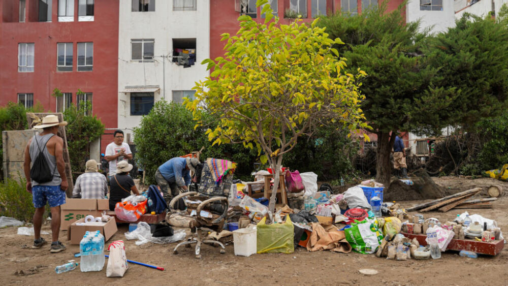 Unos damnificados por las fuertes lluvias cuidan algunas de sus pertenencias el 25 de febrero de 2026 en Arequipa, en el sur de Perú