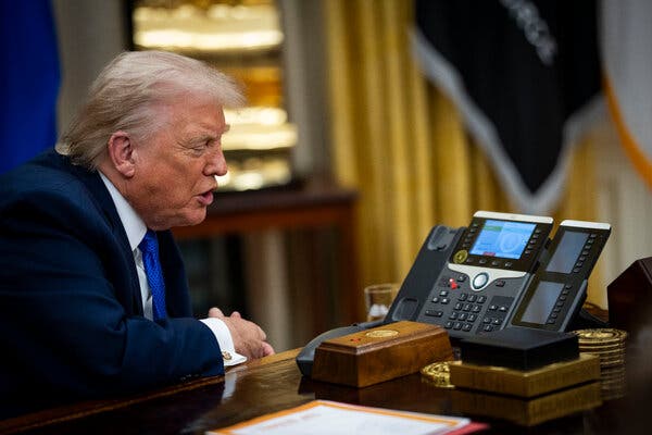 El presidente Trump, con traje oscuro y corbata azul, habla por un altavoz.