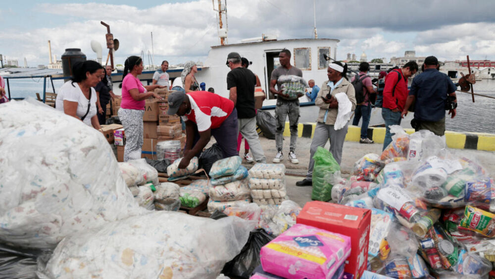 Activistas de Nuestra América y autoridades cubanas descargan ayuda humanitaria del buque "Granma 2.0" en el puerto de La Habana, el 24 de marzo de 2026.