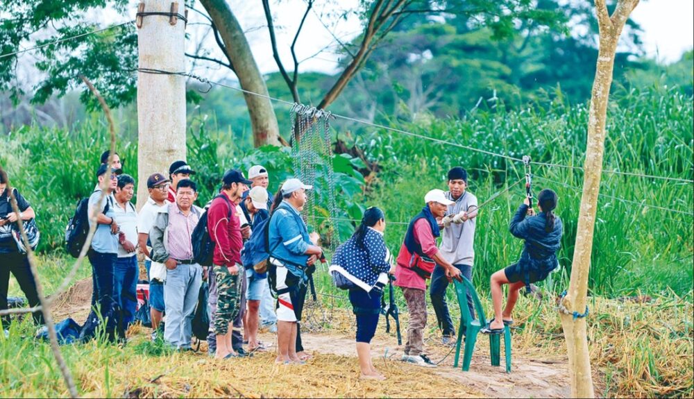 Pobladores de Colpa Bélgica desafían la corriente del río a la espera de un puente