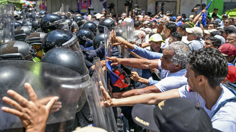 Opositores al gobierno de la presidenta interina de Venezuela, Delcy Rodríguez, se enfrentan a la policía durante una manifestación en Caracas el 9 de abril de 2026, en la que reclaman aumentos salariales y de las pensiones.