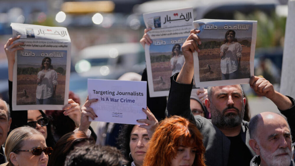 Periodistas levantan periódicos en los que aparece el retrato de la periodista libanesa Amal Khalil, asesinada el miércoles en un bombardeo aéreo israelí, durante una protesta organizada en Beirut, Líbano, el 23 de abril de 2026, para condenar su asesinato.