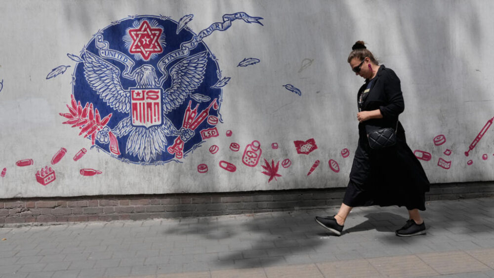 Una mujer pasa junto a un mural contra Estados Unidos pintado en la pared de la antigua embajada estadounidense en Teherán, Irán, el sábado 25 de abril de 2026. (Foto AP/Vahid Salemi)