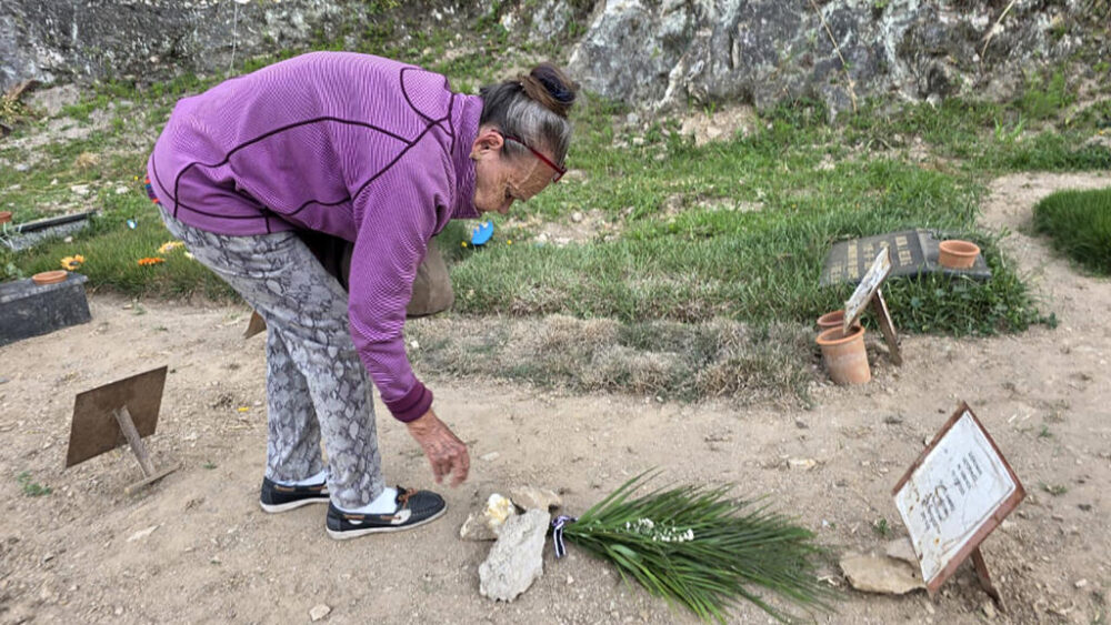 Carmen Nava deposita flores en la tumba de su hijo, el preso político Victor Quero Navas, en un cementerio de Caracas el 7 de mayo de 2026.