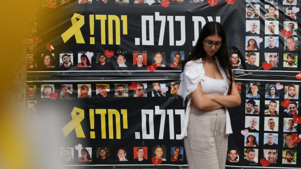 Una mujer frente a unas pancartas que representan a los rehenes secuestrados durante el mortífero ataque del 7 de octubre de 2023, en la «Plaza de los Rehenes», en Tel Aviv, el 12 de octubre de 2025.