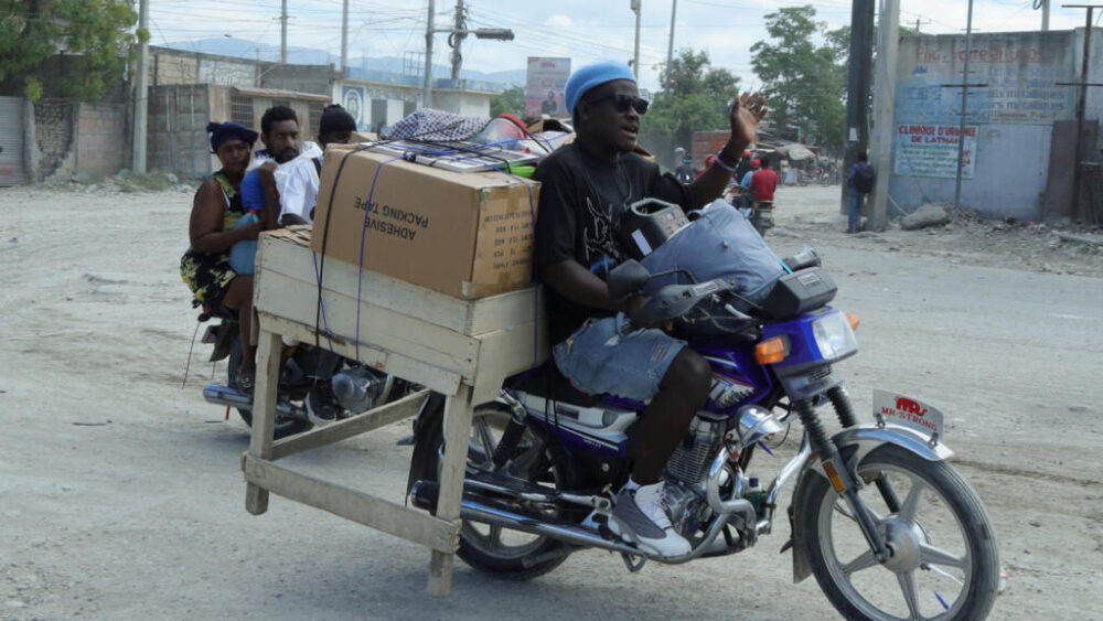 Unos residentes transportan sus pertenencias en motocicleta mientras huyen de sus hogares en Cité Soleil, tras el recrudecimiento de los enfrentamientos entre pandillas rivales en la capital haitiana durante el fin de semana, en Puerto Príncipe, Haití, el 11 de mayo de 2026.