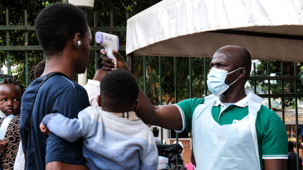 Un funcionario sanitario utiliza un termómetro para tomar la temperatura a las personas frente al Hospital Musulmán de Kibuli, en Kampala (Uganda), el sábado 16 de mayo de 2026.