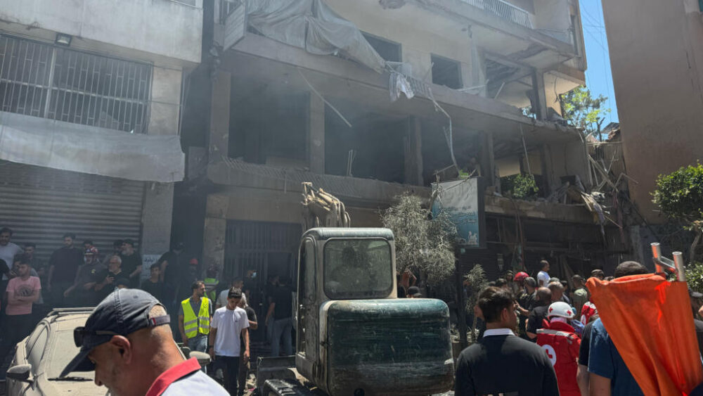Varias personas en el lugar donde un ataque aéreo israelí alcanzó un edificio de apartamentos en Dahiyeh, en los suburbios del sur de Beirut (Líbano), el domingo 14 de junio de 2026. (Foto AP/Bilal Hussein)
