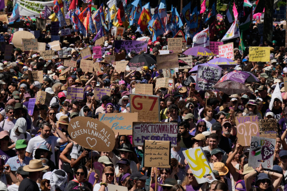 Los manifestantes sostienen carteles y pancartas mientras participan en una manifestación contra el G7 en Ginebra, Suiza, el domingo 14 de junio de 2026, antes de la cumbre del G7 prevista para los días 15 a 17 de junio.